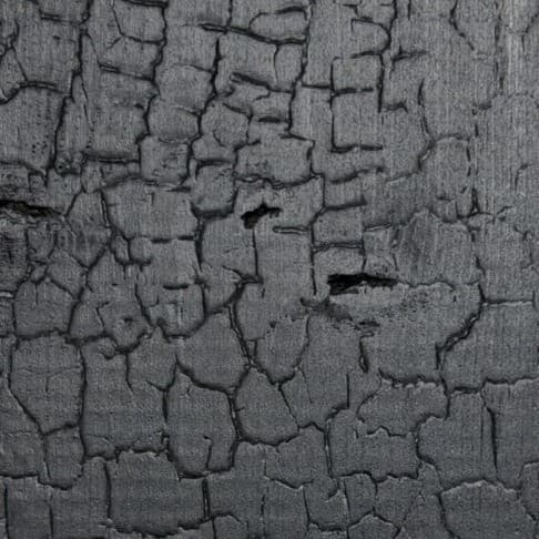 Charred black timber with a cracked, textured surface